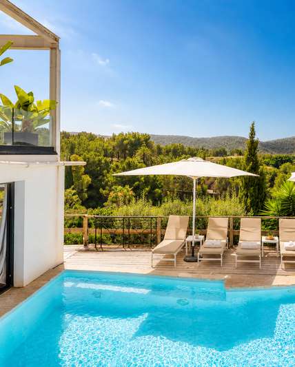 Pool terrace with sun loungers and hillside view