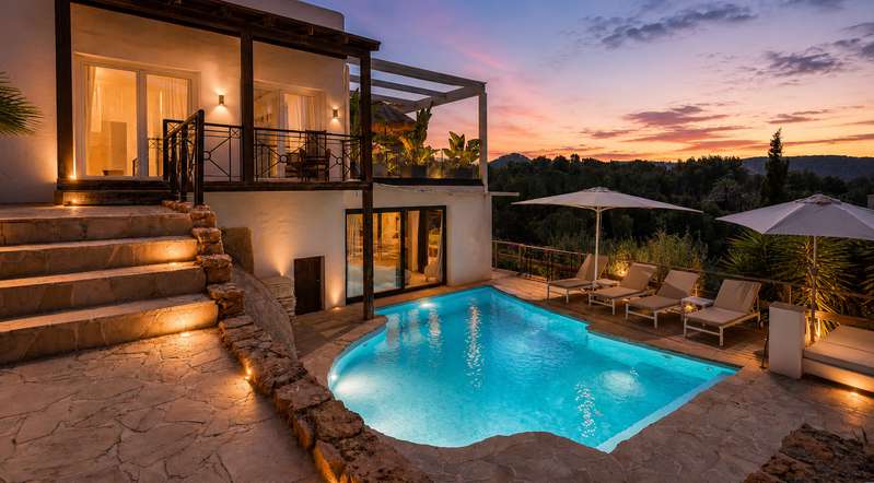 Sea-view villa in Can Furnet, Ibiza at sunset with illuminated pool